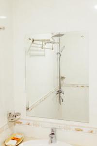 Baño con espejo sobre un lavabo en Douangpraseuth Hotel en Vientián
