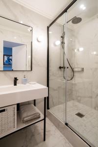 uma casa de banho com um lavatório e um chuveiro em SUITE APOLLINAIRE : au cœur de la Rive Gauche, neuf, design, 2/4 personnes em Paris