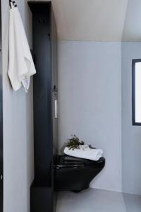 a bathroom with a black toilet and a towel at Magical Pond Nature Igloos in Ruka