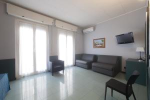 a waiting room with a couch and a tv at Hotel Tirreno in Genoa