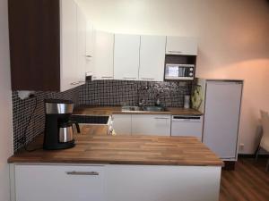 a kitchen with white cabinets and a coffee maker on a counter at Jakobstad Pietarsaari city center apartment 55m2 in Pietarsaari