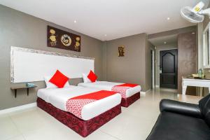 a hotel room with two beds and a couch at Natural Beach Hotel Pattaya in Pattaya