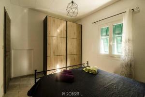 Schlafzimmer mit einem Bett mit einem Kopfteil aus Holz und einem Fenster in der Unterkunft Accogliente Bussana 1 in Sanremo