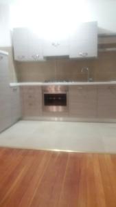 a kitchen with white cabinets and a wooden floor at Casamanu in Enego