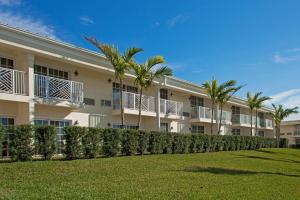 un grand bâtiment avec des palmiers devant lui dans l'établissement Holiday Inn Express- North Palm Beach and IHG Hotel, à Juno Beach