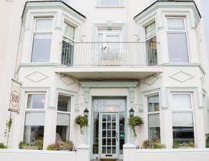 a white building with a balcony in front of it at Avarest House BB Adults Only in Portrush