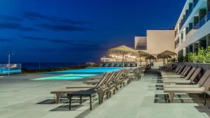a resort with a swimming pool and lounge chairs at Hotel Verde Mar & SPA in Ribeira Grande