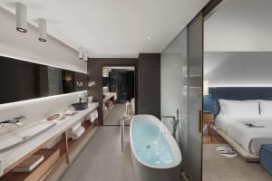 a bathroom with a bath tub and a bed at Mandarin Oriental, Barcelona in Barcelona