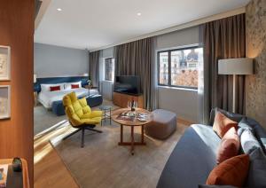 een hotelkamer met een woonkamer met een bed en een bank bij Mandarin Oriental, Barcelona in Barcelona