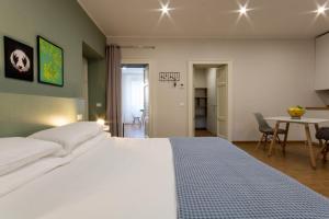 a bedroom with a large white bed and a table at aqualago casa vacanze apartment E in Verbania