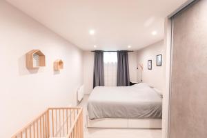 a small bedroom with a bed and a window at Au détour des Places in Arras