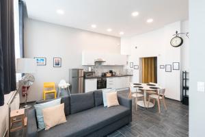 a living room with a couch and a kitchen at Au détour des Places in Arras