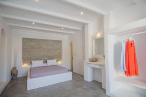 a bedroom with a bed and a brick wall at Olga in Ios Chora