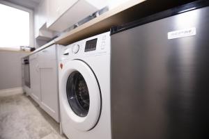 uma máquina de lavar roupa branca numa lavandaria em White Home Room em Białystok