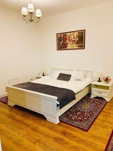 1 Schlafzimmer mit einem großen weißen Bett und 2 Tischen in der Unterkunft A&C Hotel Rooms - Up in the Sky in Oradea