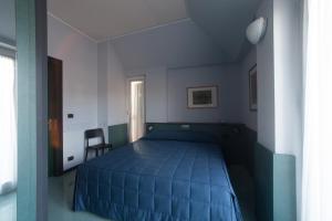 a bedroom with a blue bed and a chair at Hotel Tirreno in Genoa
