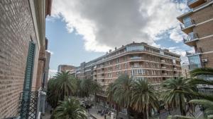 a street with palm trees and a large building at Soho Boutique Colón in Málaga