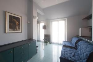 a living room with a blue couch and a window at Hotel Tirreno in Genoa