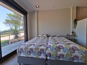 een slaapkamer met een bed en een groot raam bij Casa de la Luz in Begur