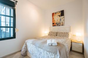 um quarto com uma cama com duas toalhas em La Corrala de Triana em Sevilha