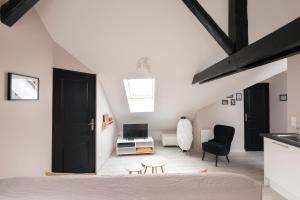 a bedroom with a black door and a living room at Au détour des Places in Arras