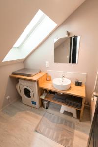 a bathroom with a sink and a washing machine at Au détour des Places in Arras +19 photos