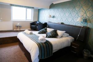a bedroom with a large bed with a chair at Avarest House BB Adults Only in Portrush