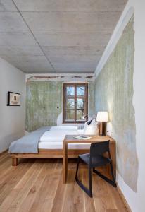 a bedroom with a bed and a desk and a window at Hotel Röhrl in Sinzing