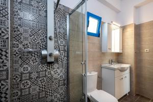 a bathroom with a toilet and a glass shower at Mikro Nisi Studios in Agios Nikolaos