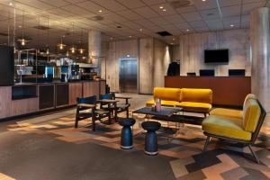 a lobby with chairs and tables and a bar at Quality Hotel River Station in Drammen