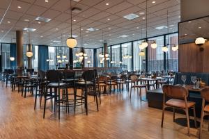 a restaurant with tables and chairs and windows at Quality Hotel River Station in Drammen