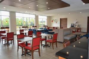 um restaurante com mesas, cadeiras e janelas em Holiday Inn Express & Suites - Charlotte NE - University Area, an IHG Hotel em Charlotte