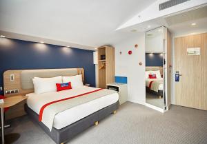 a hotel room with a large bed and a mirror at Holiday Inn Express - Istanbul - Atakoy Metro, an IHG Hotel in Istanbul