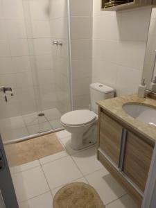 a bathroom with a toilet and a shower and a sink at Apto em santos 900 m praia in Santos
