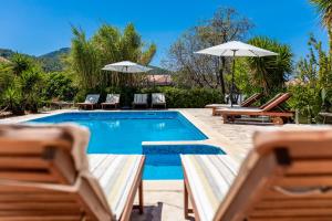 - une piscine avec des chaises et des parasols à côté dans l'établissement Komun Apartments, à Vela Luka