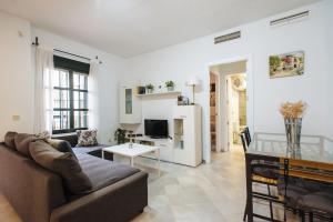 een woonkamer met een bank en een tafel bij La Corrala de Triana in Sevilla