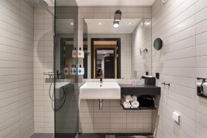 ein Bad mit einem Waschbecken und einer Dusche in der Unterkunft Quality Hotel River Station in Drammen