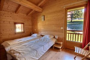 - 2 lits dans une cabane en rondins avec fenêtre dans l'établissement CHALET INDIVIDUEL -SAUNA - WIFI- SAINT JEAN D'AULPS - 14 PERSONNES - CHALET COFFY, à Saint-Jean-dʼAulps