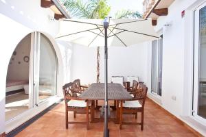 - une salle à manger avec une table et un parasol dans l'établissement Magallanes 26, à Can Picafort