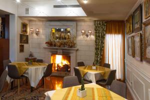 a dining room with two tables and a fireplace at Hotel Locanda Al Sole in Castello di Godego