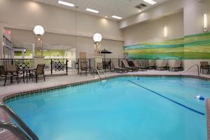 una piscina en una habitación de hotel con sillas y mesas en Holiday Inn Portland-Airport I-205, an IHG Hotel en Portland