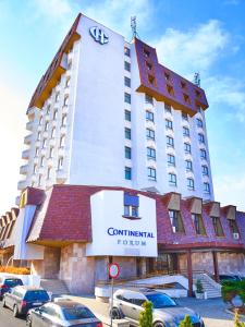 a large hotel with cars parked in front of it at Continental Forum Tirgu Mures in Târgu-Mureş