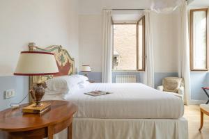 una camera con letto e tavolo con lampada di Casa Giulia by Burghesius a Roma