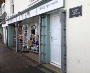 a store with a white door on the side of a street at Goose's Getaway in Wells next the Sea
