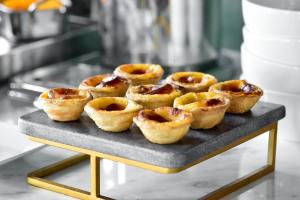 a tray of puff pastry tarts on a table at My Story Hotel Augusta in Lisbon