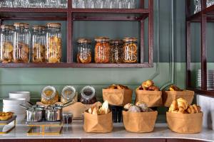 a buffet with jars of food and baskets of bread at My Story Hotel Augusta in Lisbon