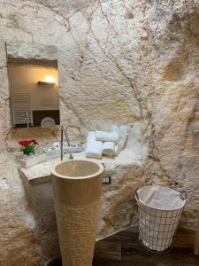 Baño de piedra con lavabo y espejo en Panta Rei en Ostuni