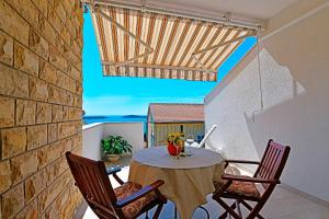 a patio with a table and chairs on a balcony at Apartments Tamara in Hvar