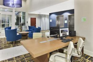 an office with a desk with a computer and blue chairs at Holiday Inn Augusta West I-20, an IHG Hotel in Augusta