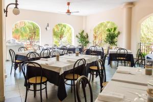 a dining room with tables and chairs and windows at Salinello Village in Tortoreto Lido